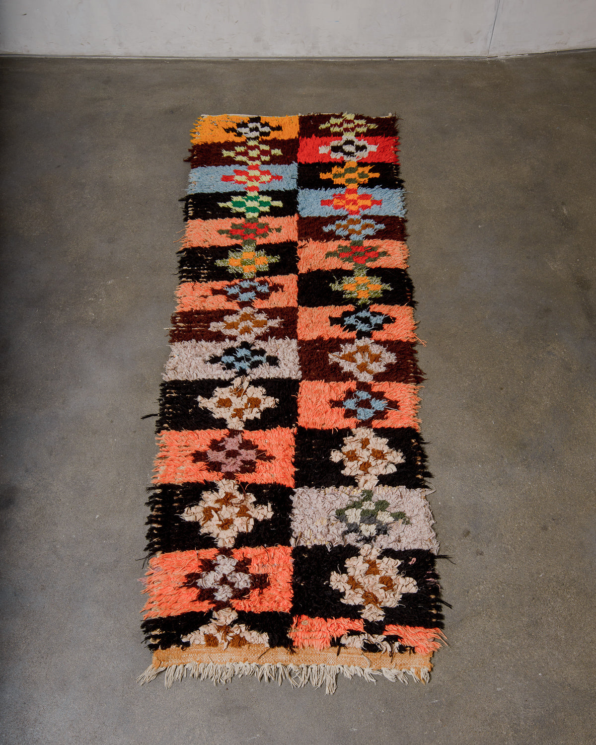 Multicoloured patterned rug on a concrete floor